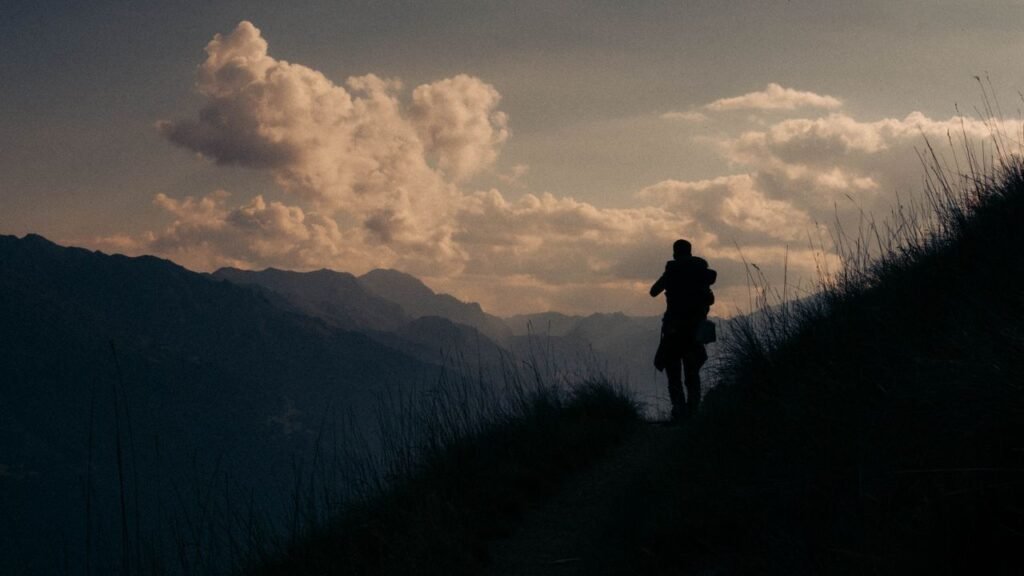 A person standing calmly on a mountain path