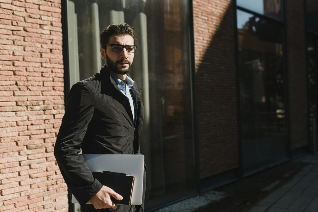 A person standing confidently at a crossroads with a laptop or notebook, looking toward different paths