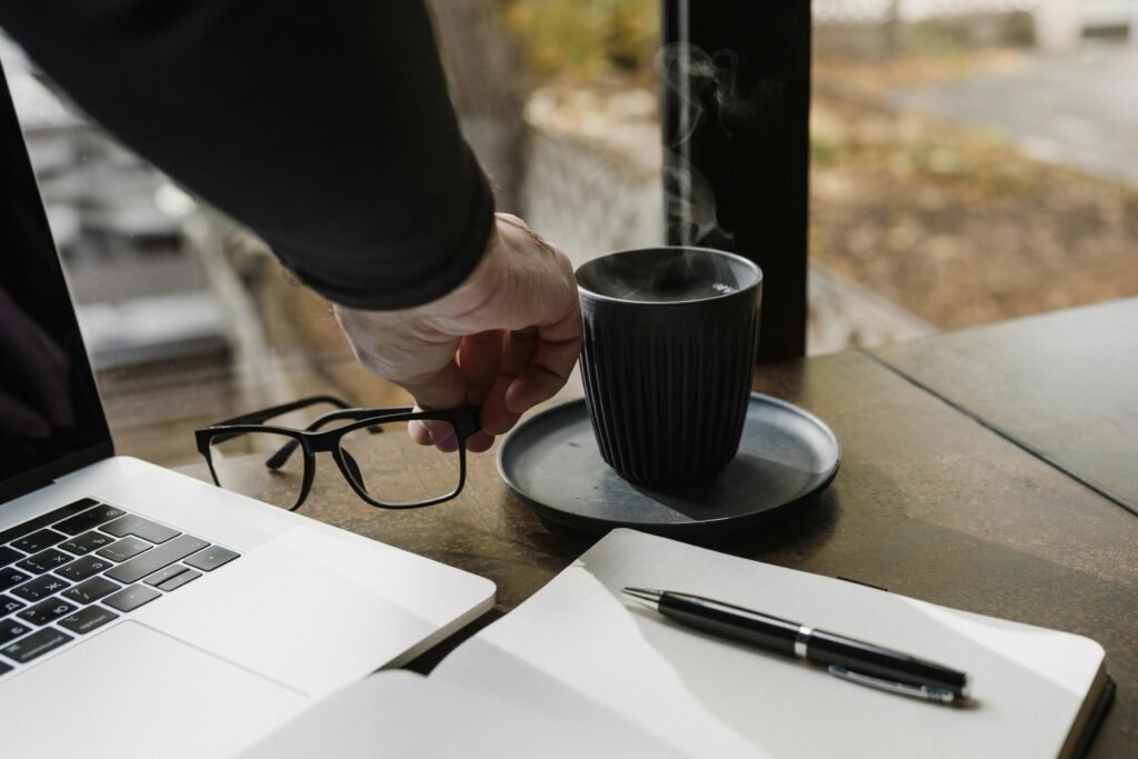 A calm scene showing a laptop closed beside a notebook, cup of tea