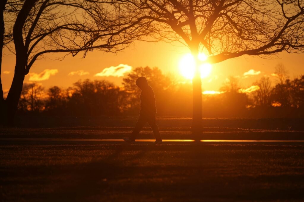 A calm person sitting beside a window or walking slowly on a quiet path