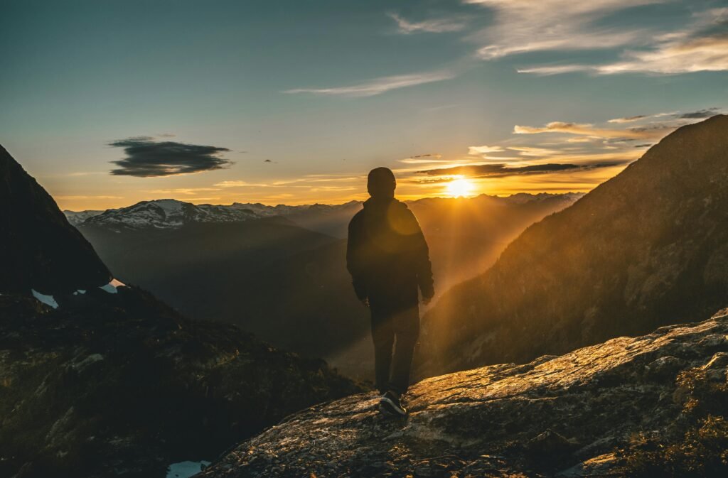 A person standing confidently on a quiet path during sunrise