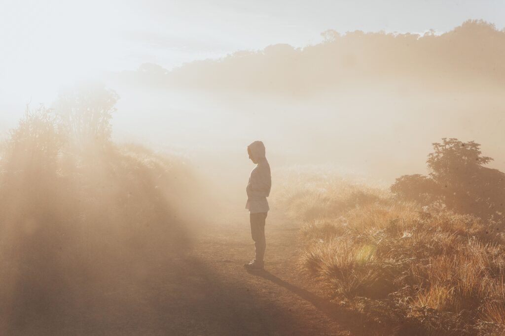 A person standing confidently at the beginning of a clear path toward sunrise