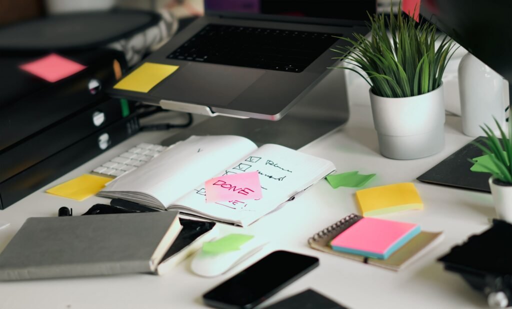 A professional working at a desk with a notebook, laptop, and growth checklist