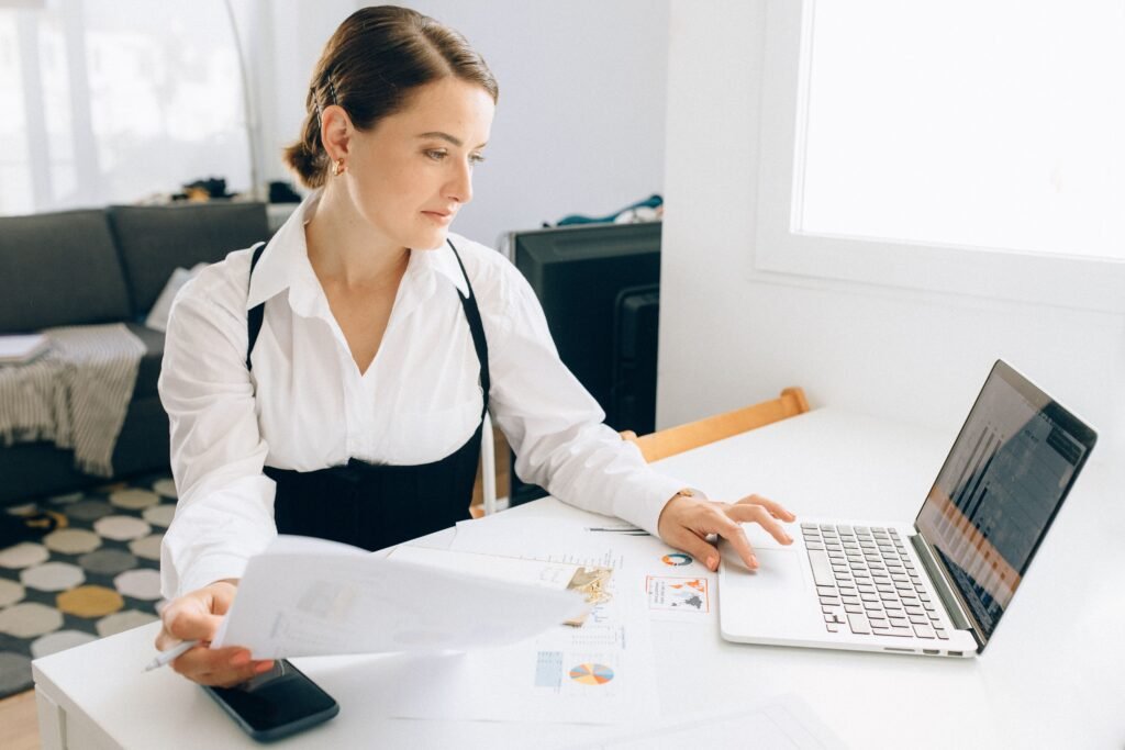 A professional reviewing a resume, LinkedIn profile, and portfolio on a laptop