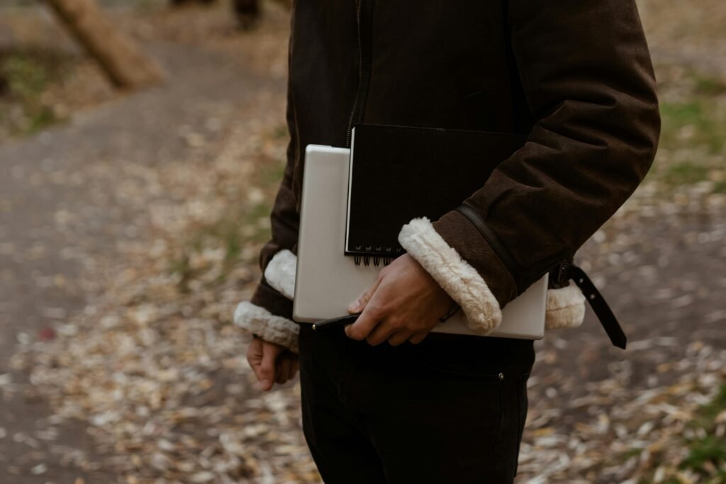 A professional standing at a crossroads with a notebook or laptop, looking toward a clear path ahead