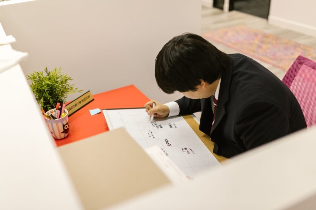 A person looking at a planner, calendar, and task list on a clean desk