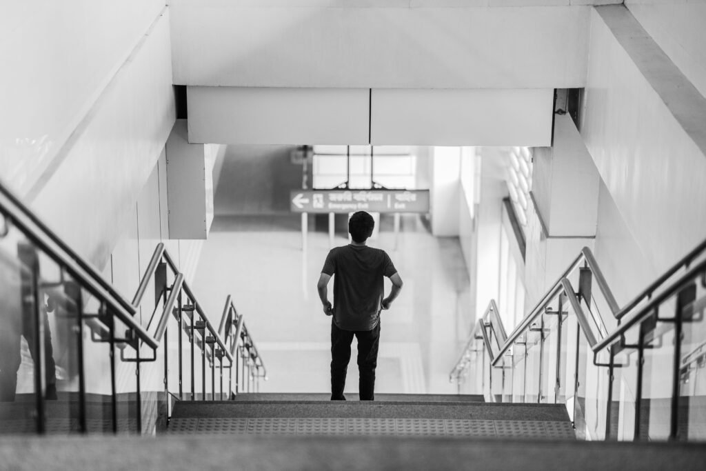 A person standing at the beginning of a path or staircase, looking forward with determination