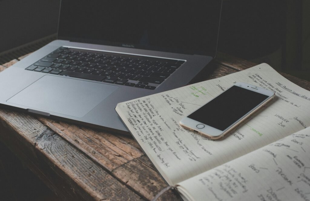 A calm workspace with a laptop, notebook, timer, and phone placed away from the desk