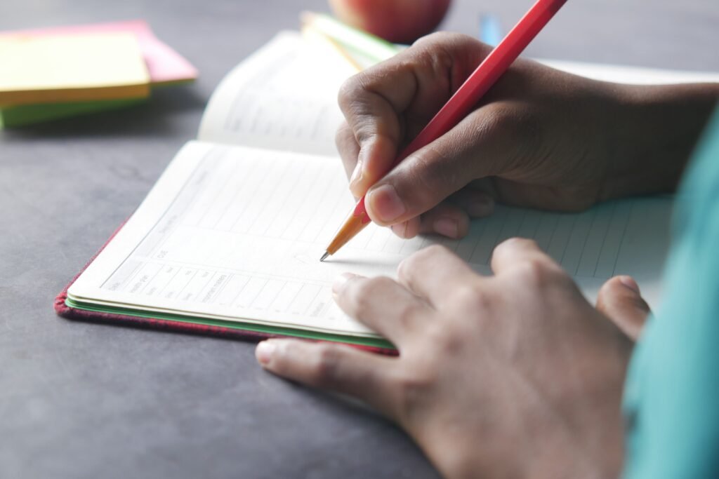 A person standing at the edge of a road or looking at an open notebook with goals written down