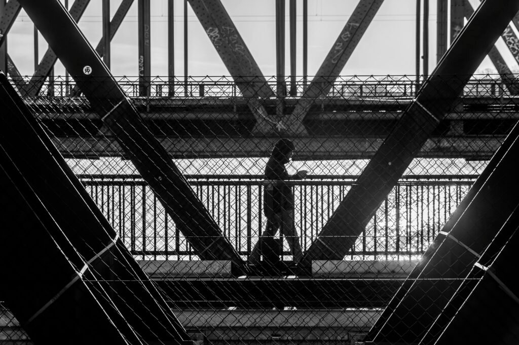 A person walking confidently along a new path, crossing a bridge