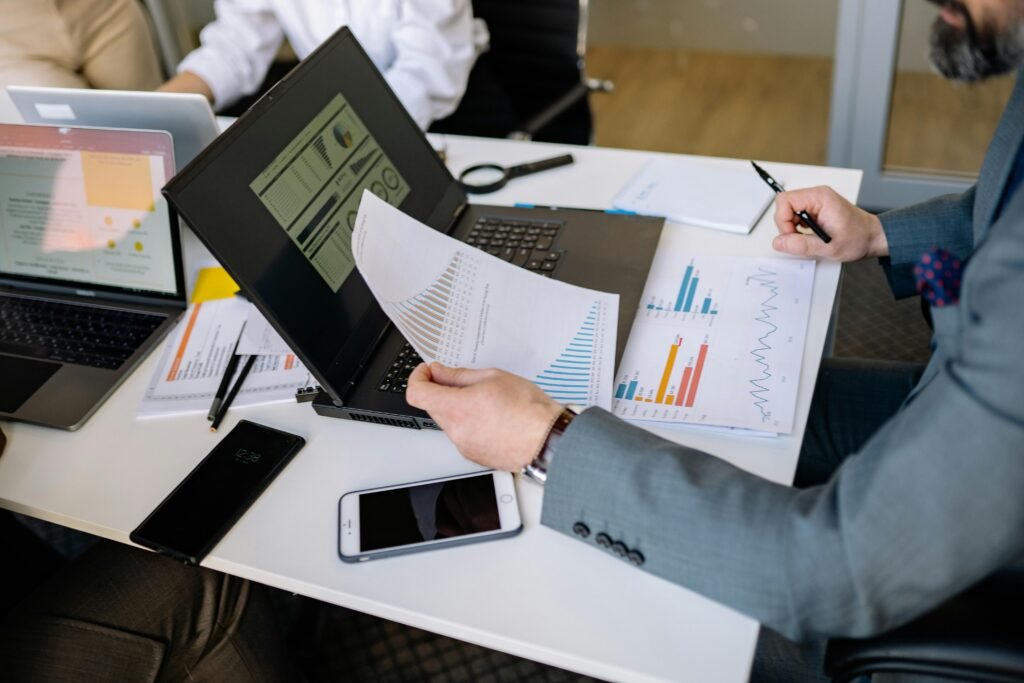 A professional working on a laptop with digital dashboards, documents, charts, and productivity tools on screen
